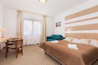 ein Schlafzimmer mit einem Bett, einem Schreibtisch und einem Stuhl in der Unterkunft Willa Arielka in Rewal