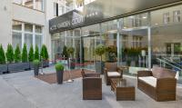 a store front of a building with chairs and plants at Hotel Garden Court in Prague