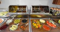 a buffet filled with different types of food in bowls at Hotel Garden Court in Prague