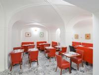 a dining room with red chairs and tables at Hotel Garden Court in Prague