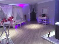 a purple room with two beds and pink lighting at La Paillote Exotique Spa in Beaucaire