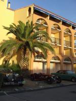 two old cars parked in front of a building with a palm tree at Hotel Alhambra in Cap d&#39;Agde