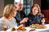 a man and woman sitting at a table with a plate of food at Novotel Brussels City Centre in Brussels