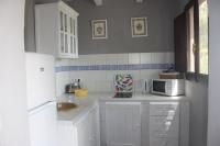 a white kitchen with a sink and a microwave at Molino El Mastral in Tarifa