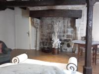 a living room with a table and a stone wall at La Maison Rouge in Chinon