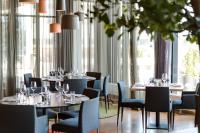 una sala da pranzo con tavoli, sedie e finestre di Quality Hotel Expo a Fornebu