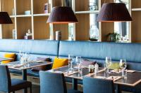 una sala da pranzo con tavoli, sedie e lampade di Quality Hotel Expo a Fornebu
