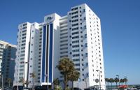 ein großes weißes Gebäude mit Palmen davor in der Unterkunft Club Regency at Regency Towers in Myrtle Beach