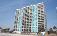 ein hohes Gebäude mit blauen Fenstern am Strand in der Unterkunft Club Regency at Regency Towers in Myrtle Beach