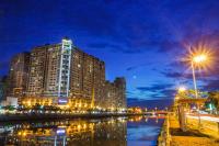a tall building at night next to a river at Wei-Yat Grand Hotel in Anping