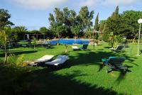 a yard with chairs and a swimming pool at Hotel Punta Sur in Tarifa