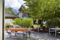 a patio with tables and chairs and a building at HYPERION Hotel Garmisch - Partenkirchen in Garmisch-Partenkirchen