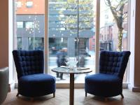 two chairs and a table with wine glasses on it at ABode Manchester in Manchester