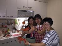 three people standing in a kitchen holding lobsters at Doll House Lodge in Hengchun South Gate