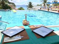 einen Tisch mit Tellern und Küchenutensilien neben einem Pool in der Unterkunft La Vista Resort in Simpson Bay