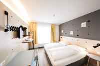 Un dormitorio con una gran cama blanca. en Hotel Tullnerfeld, en Tulln