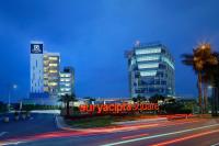 a city street with two tall buildings at night at BATIQA Hotel & Apartments Karawang in Karawang