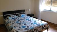 Un dormitorio con una cama con un edredón azul y blanco. en Modern City Center Apt, en Lárnaca