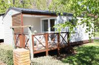 une cabine avec une grande terrasse dans une cour dans l&#39;établissement Camping La Clé des Champs, à Saint-Nectaire