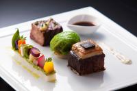 Un plato blanco cubierto con diferentes tipos de comida. en The Tokyo Station Hotel, en Tokio