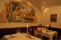 jadalnia z dwoma stołami i dużym obrazem na ścianie w obiekcie Hotel Valacia w mieście Pozza di Fassa