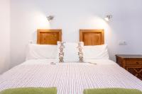 1 dormitorio con cama blanca y almohada verde en Pensión Bellavista, en Puerto Pollensa