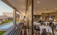 a restaurant with white tables and chairs on a balcony at Springbok Inn in Springbok
