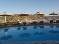 a swimming pool with chairs and umbrellas at Krotiri Bay -adults only in Parikia