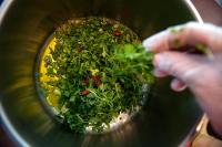 米克诺斯城米科诺斯埃琳娜酒店的一个人正在锅里搅拌蔬菜。