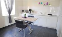 a kitchen with a table and two chairs and a sink at Aux Jardins de L&#39;Isle in Vienne