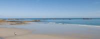 a person walking on a beach with the ocean at Le Château de Sable in Plougasnou