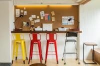 a counter with two red and two yellow stools at Mr. Lobster’s Secret Den design hostel in Taipei