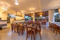 ポルト・セグロにあるPorto Geraes Praia Hotelの木製のテーブルと椅子と窓のあるレストラン