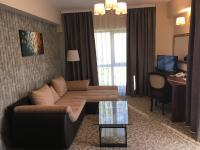 a living room with a couch and a desk in a hotel room at Hotel Arnia in Iaşi