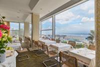 リッチョーネにあるHotel Fedora Riccione - FRONTE MAREのテーブルと椅子があり、海が見えるレストラン