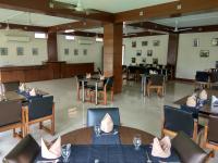 een eetkamer met tafels, stoelen en een tafelblad bij Polo Tura Hotel in Tura