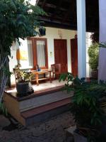 un porche de una casa con un banco y plantas en Wahwik&#39;s House, en Ubud