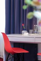 a red chair sitting in front of a white desk at Hotel Mille Stelle City in Heidelberg