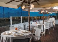 Hotel Souvenir في ليدو دي سافيو: مطعم بطاولات بيضاء وكراسي ومظلات