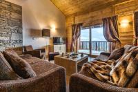 a living room with two couches and a large window at CGH Résidences &amp; Spas Chalet Les Marmottons in La Rosière