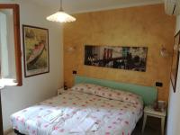 a bedroom with a bed with a red and white comforter at Affittacamere Ca&#39; Dei Lisci in Riomaggiore