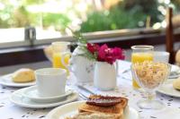 a table with plates of breakfast foods and drinks at Pousada Casa do Catavento in Búzios