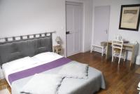a bedroom with a large bed and a desk and a table at Chambres d&#39;Hôtes Villa Bellevue in Albi