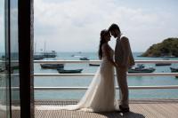 a bride and groom standing on a deck at Pousada Casa do Catavento in Búzios