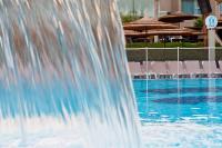 einen Brunnen in einem Pool mit Stühlen in der Unterkunft U Coral Beach Club Eilat – Ultra All inclusive in Eilat