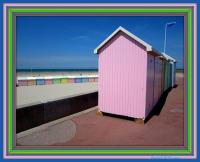 a pink shack on the side of a beach at L Imperatrice in Berck-sur-Mer