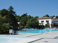 a swimming pool with chairs and people in the water at Village Océanique in Le Bois-Plage-en-Ré