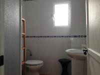 a bathroom with a toilet and a sink and a window at Apartamentos Casa la Costanilla in Vejer de la Frontera