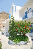 una gran olla de flores rojas delante de un edificio en Afroditi Hotel, en Kamarai