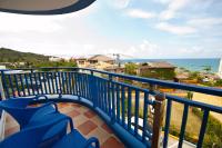 a balcony with blue chairs and a view of the ocean at Haisu Homestay in Eluan
